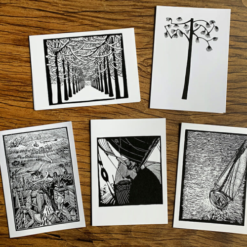 five black and white notecards lying on a wooden table