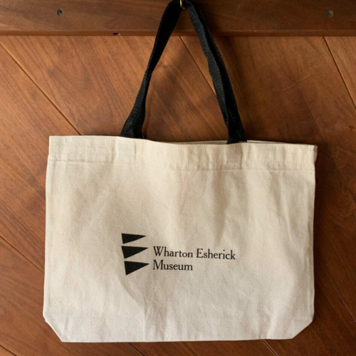 natural canvas tote bag with black museum logo and handles