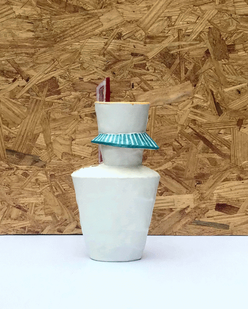tall white ceramic vessel with turquoise "awning" feature and tall three pane red window. Back side has faint yellow grid on surface
