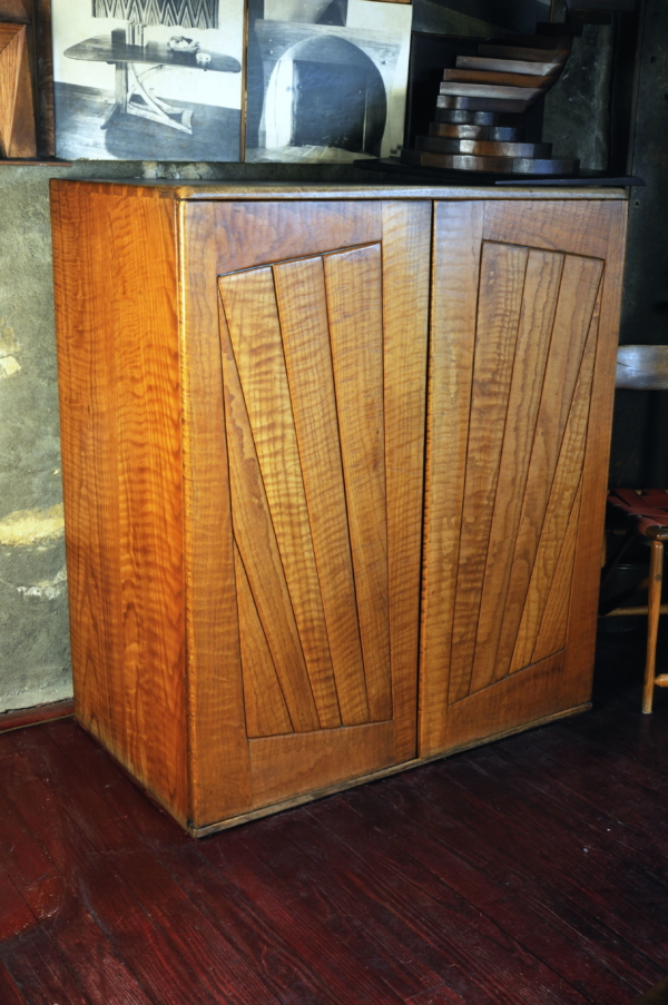 wood cabinet with radial patterned boards on the doors.